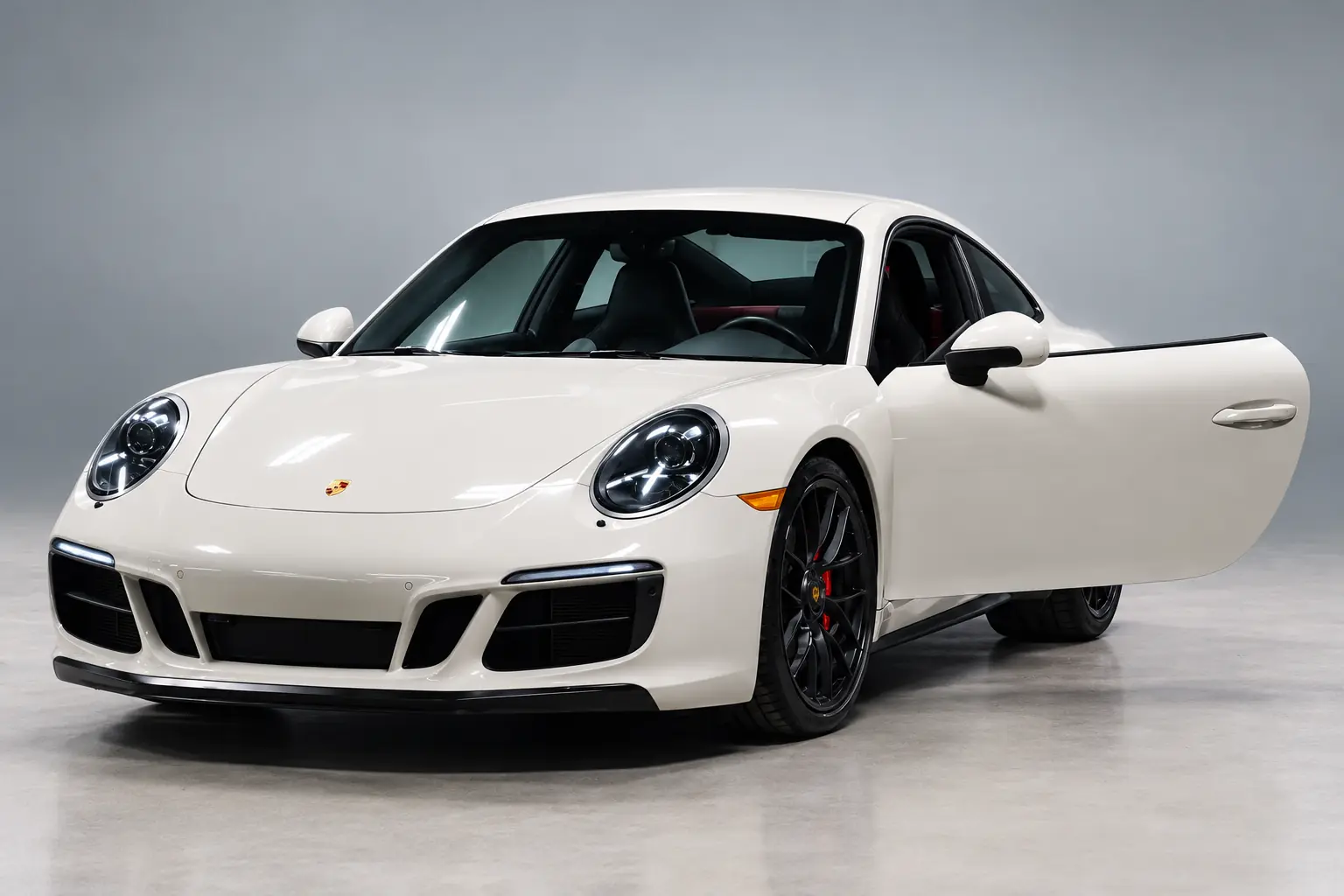 White Porsche 911 with the driver door open